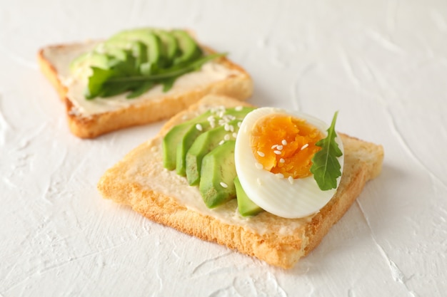 Tostadas con aguacate y huevo en blanco, de cerca