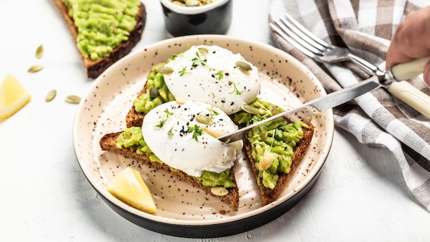 Tostadas de aguacate y huevos escalfados sobre un fondo claro vista superior Desayuno con comida vegetariana concepto de dieta saludable