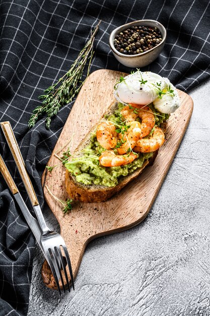 Tostadas con camarones, langostinos, aguacate y huevo escalfado. Vista superior