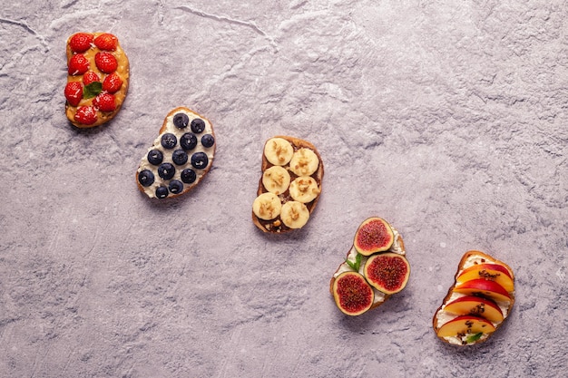 Tostadas caseras de verano con mantequilla de nuez de queso crema y frutas y bayas