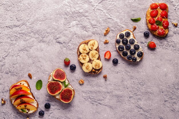 Tostadas caseras de verano con mantequilla de nuez de queso crema y frutas y bayas