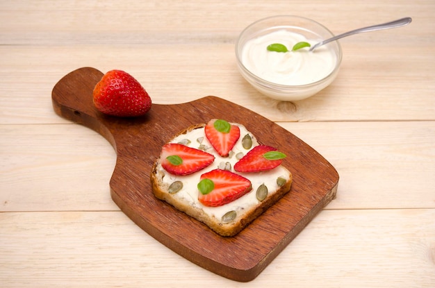 Tostadas dulces vegetarianas con queso y fresas y crema en la mesa