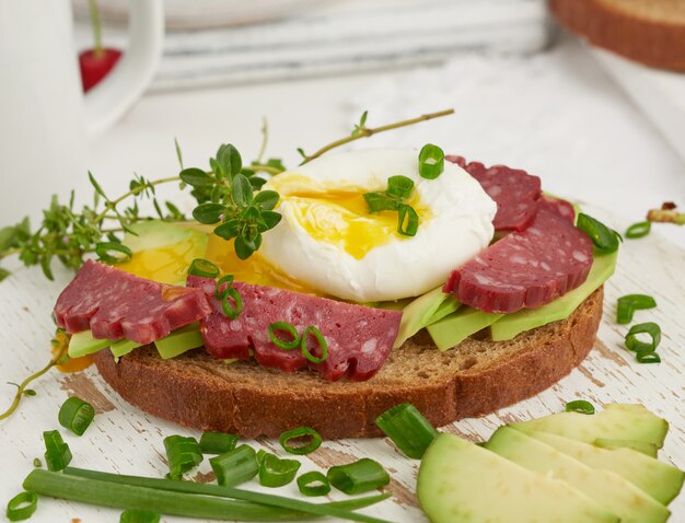 Tostadas con huevo escalfado y aguacate en una tabla redonda