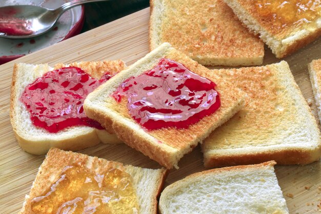 Tostadas con mermelada de fresa y mermelada en una tabla para cortar