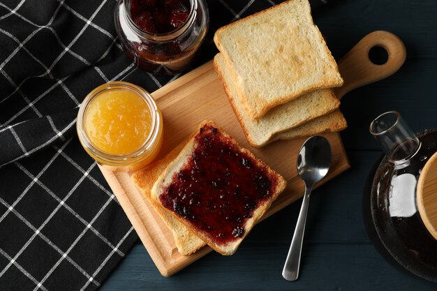 Foto tostadas, mermelada y té sobre fondo de madera, vista superior