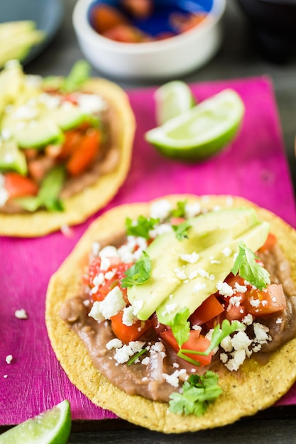 Tostadas mexicanas vegetarianas frescas sobre tabla de cortar morada.