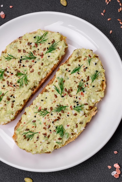 Tostadas a la parrilla con pasta de aguacate huevos queso crema sal especias y hierbas