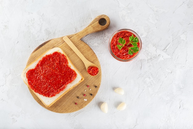 Tostadas con pasta de ajvar de pimiento dulce sobre una tabla de madera Vista superior de orientación horizontal