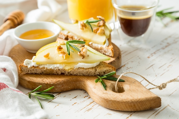 Tostadas con pera, queso de cabra y nueces, miel, romero.