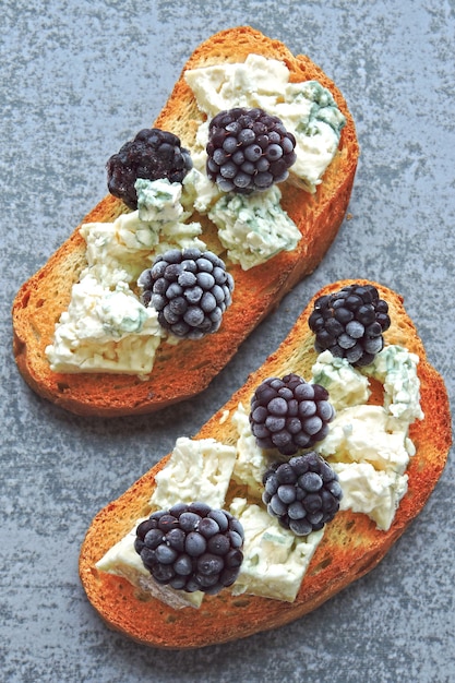 tostadas con queso azul y moras.