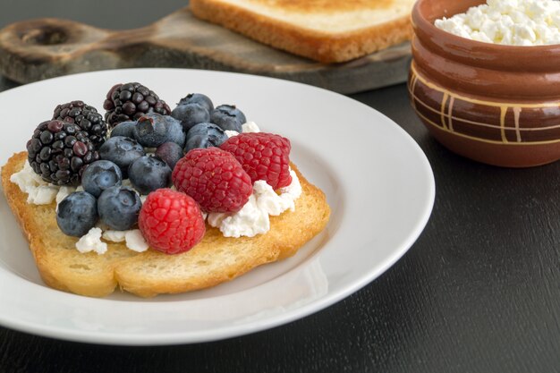 Tostadas con queso cottage y bayas frescas.