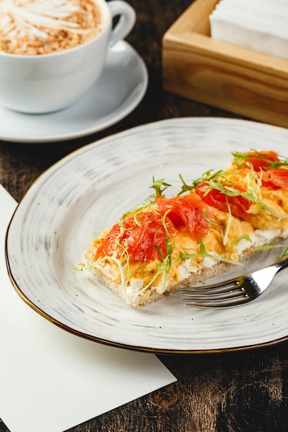 Tostadas con queso crema huevos revueltos y salmón desayuno en la cafetería