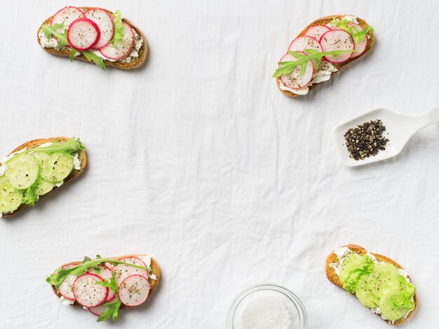 Foto unas tostadas de rábano y pepino con ricotta, ensalada y papel