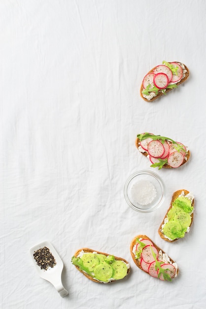 Unas tostadas de rábano y pepino con ricotta, ensalada y papel