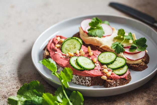 Tostadas de remolacha y hummus clásico. Concepto de comida vegana.