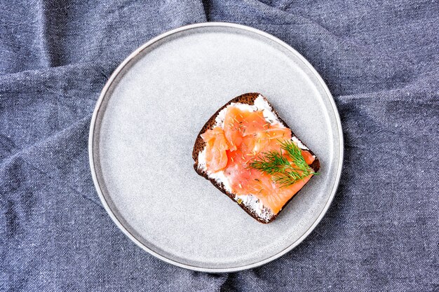 Tostadas de salmón con queso en placa sobre papel de cocina