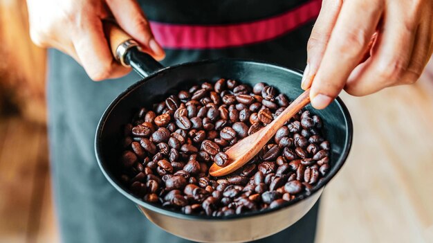 Tostado tradicional de granos de café en mano de barista xA