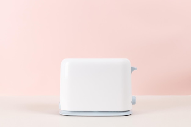Foto tostadora blanca para tostar pan con fondo rosa equipo de cocina para comida fresca por la mañana