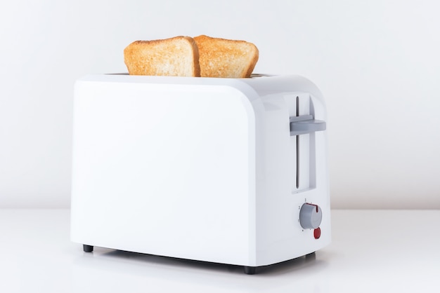 Foto tostadora con pan tostado en blanco