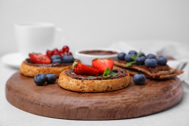 Tostas orgânicas saborosas e pães estaladiços com coberturas em closeup de mesa cinza claro