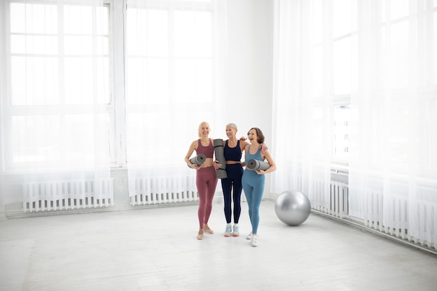 Foto totale frauen, die yogamatten halten