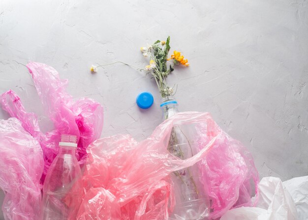 Foto tote blumen in einer plastikflasche zwischen den paketen