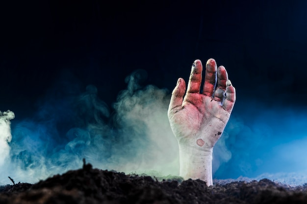 Foto tote hand, die vom boden im nebel hervorsteht