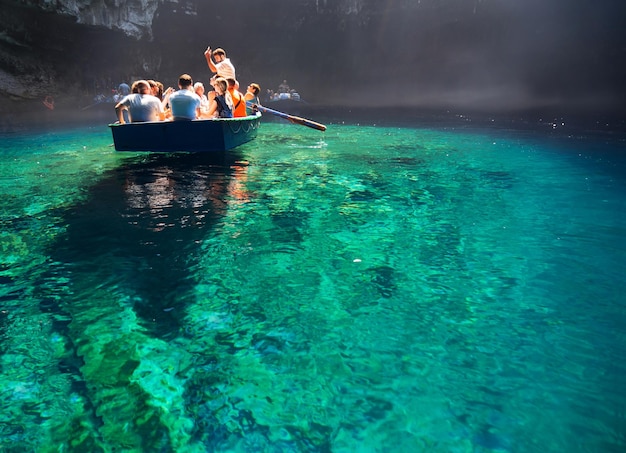 Tour en barco de turistas en una cueva con un lago subterráneo Melissani en la isla de Cefalonia, Grecia