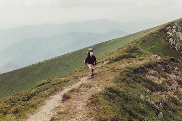 Tourismus, Berge, Lifestyle, Natur, Menschen, Selfie-Konzept - Medizinkrücke und Bein fixiert in Immobilisierung erreichten Berggipfel. Mann hat gebrochenes Bein Wegfahrsperre Gebrüll Mann repariert. Frühlingssonntag