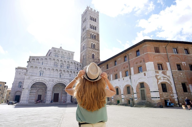 Tourismus in der Toskana Rückansicht einer jungen Touristenfrau, die die Kathedrale von Lucca in der Toskana Italien besucht