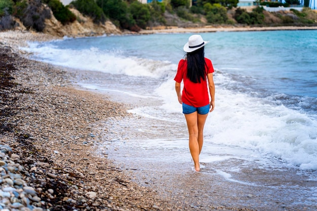 Tourismus-Reiseurlaub auf dem felsigen Meer Sexy Mädchen spaziert am paradiesischen Strand