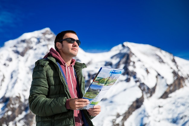 Tourist auf dem Hintergrund der schneebedeckten Berge