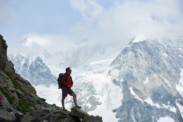 Tourist, der Berge mit Schnee betrachtet