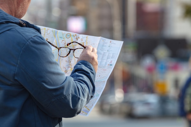 Tourist, der stattdessen die Papierkarte betrachtet, ruft an. Positive Emotionen.