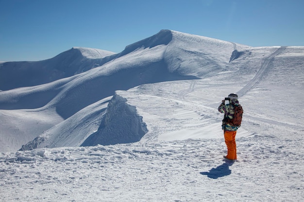 Tourist im weißen Winter mit schneebedeckten Berggipfeln