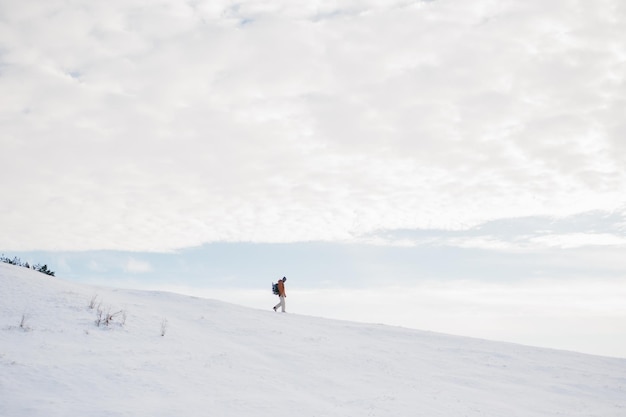 Tourist in schneebedeckten Bergen Winterlandschaft mit einem Kletterer auf dem Hintergrund des blauen Himmels