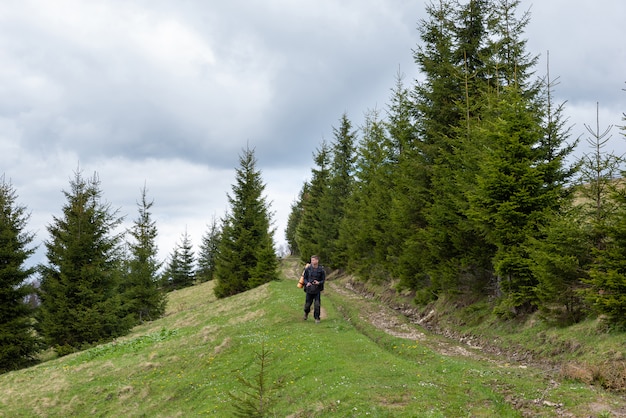 Tourist Mann geht im Wald mit einer Kamera in den Händen