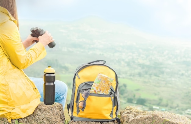 Tourist mit einem Fernglas, das die malerische Aussicht in den Bergen betrachtet