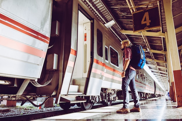 Tourist mit Rucksack am Bahnhof