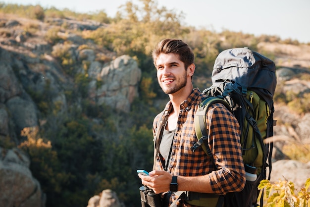 Tourist mit Rucksack, der weg in die Berge schaut