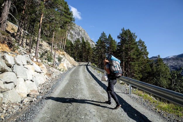 Tourist mit Rucksack geht die Straße entlang