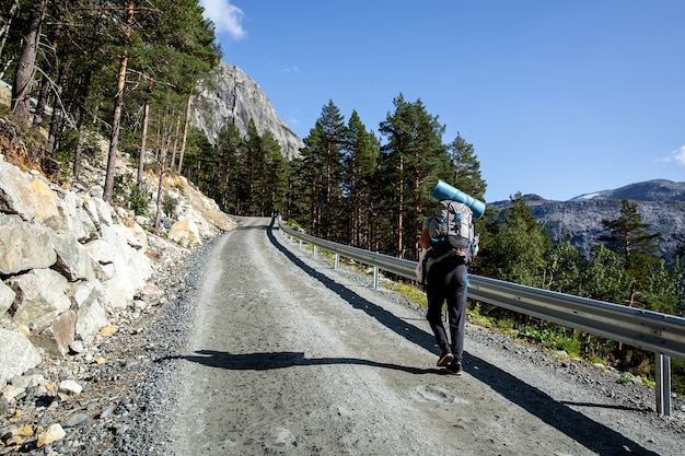 Tourist mit Rucksack geht eine Schotterstraße entlang