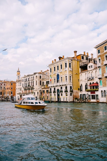 Touristen an der Uferpromenade in Venedig vor dem Hintergrund der alten Fassaden von Gebäuden