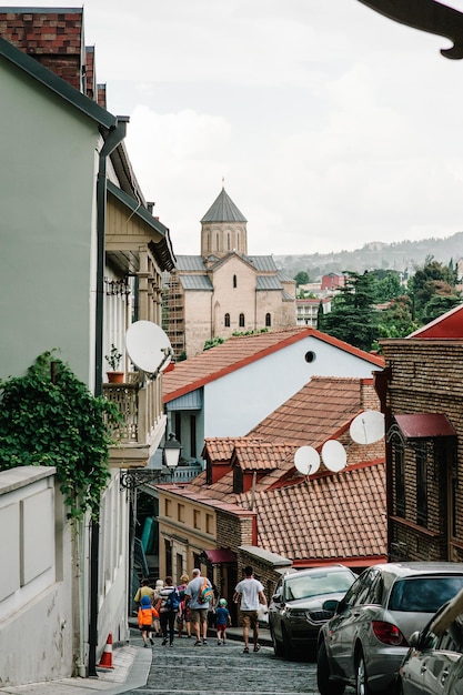 Touristen, die an einem Frühlingstag die alten Straßen des Zentrums von Tiflis, Georgien, zurückgehen. Architektur in der Altstadt von Tiflis, der Hauptstadt Georgiens