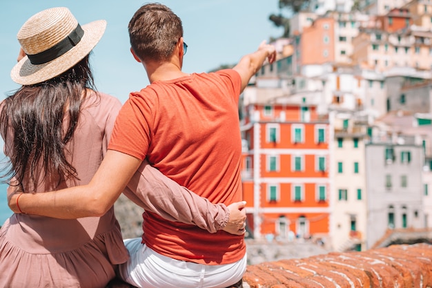 Touristen, die szenische Ansicht von Riomaggiore, Cinque Terre, Ligurien, Italien betrachten