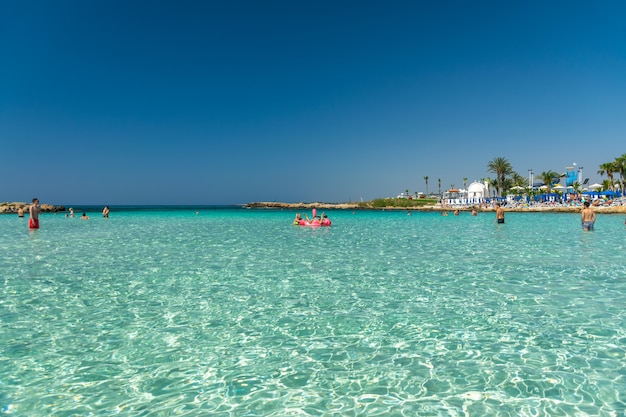 Touristen entspannen und schwimmen an einem der beliebtesten Strände der Insel.