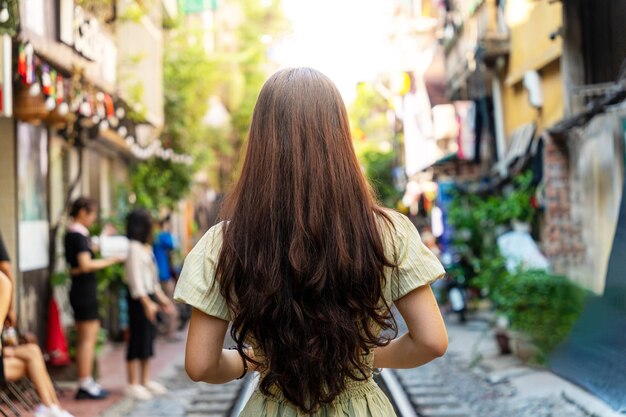 Touristen fotografieren den rasenden Zug. Die Hanoi Train Street ist eine beliebte Attraktion. Blick auf den Zug, der durch eine enge Straße der Altstadt von Hanoi fährt