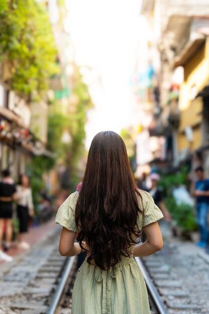 Touristen fotografieren den rasenden Zug. Die Hanoi Train Street ist eine beliebte Attraktion. Blick auf den Zug, der durch eine enge Straße der Altstadt von Hanoi fährt