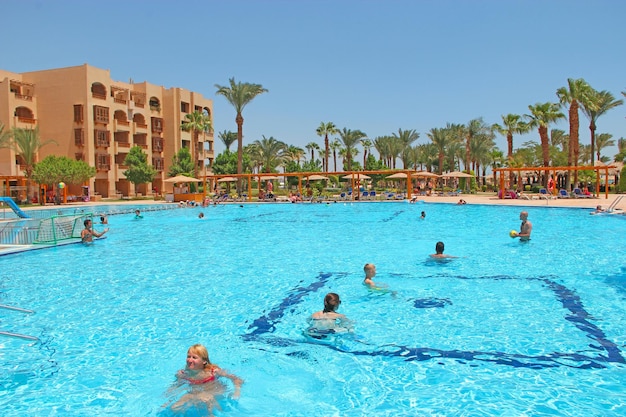 Touristen genießen die Entspannung in einem tropischen Ferienort im Pool in Ägypten Schwimmbad mit hellblauem Wasser