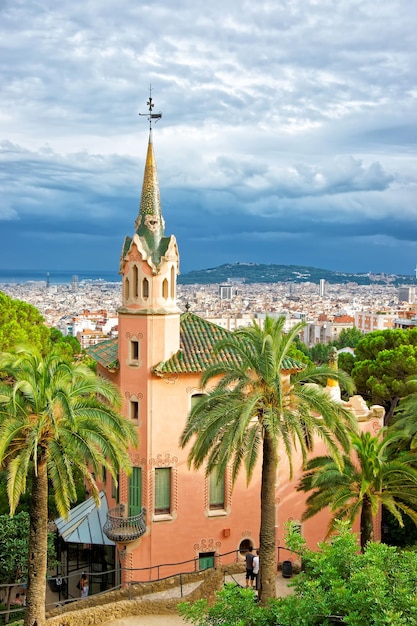 Touristen im Gaudi House Museum im Park Güell in Barcelona in Spanien. Es ist ein Haus, in dem Antoni Gaudi, ein spanischer Künstler, lebte und arbeitete. Skyline der Stadt Barcelona.